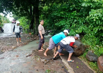 Bhabinkamtibmas Polsek Bacukiki Gotong Royong Bersama Warga Bersihkan Material Akibat Hujan Deras