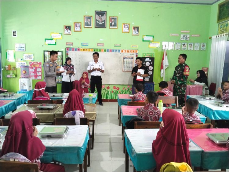 Sinergitas Bhabinkamtibmas Polsek Banggae Bersama Babinsa Dampingi Penyaluran Makanan Bergizi Gratis untuk Siswa di Kelurahan Banggae